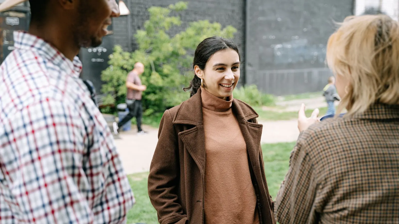Tres personas conversando al aire libre en un parque